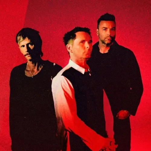 Portrait of three musicians from Muse band in dark clothing against a bright red background for the Bordeaux tour