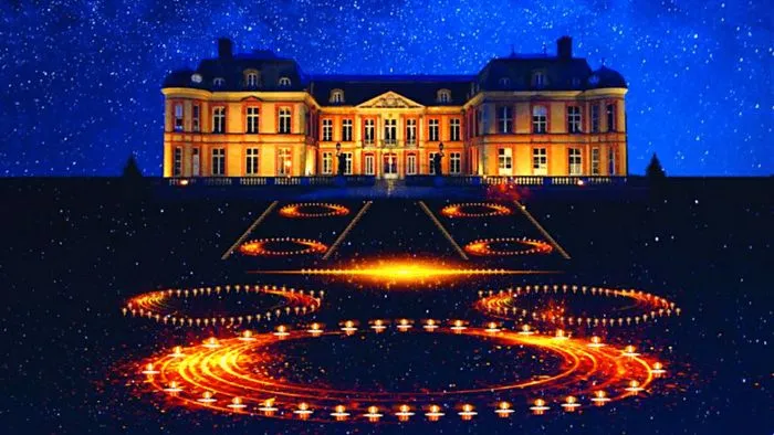 A yellow-gold lit château overlooking geometric patterns created by candlelight against a starry night sky.