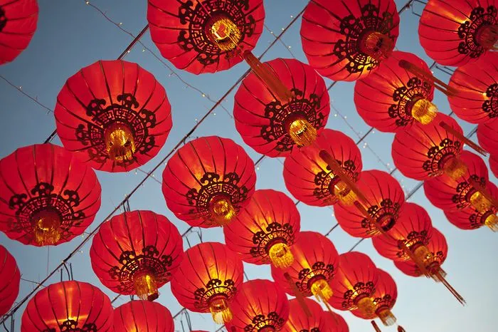 Illuminated red Chinese lanterns hanging against a blue sky, decorations for the Chinese New Year celebration in Bordeaux