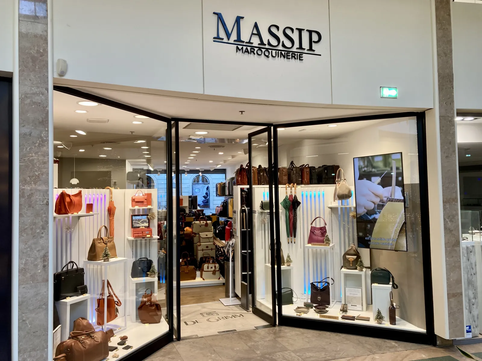 Storefront of Massip Maroquinerie in Bordeaux displaying leather handbags, wallets, and accessories in an elegant display window with modern lighting.