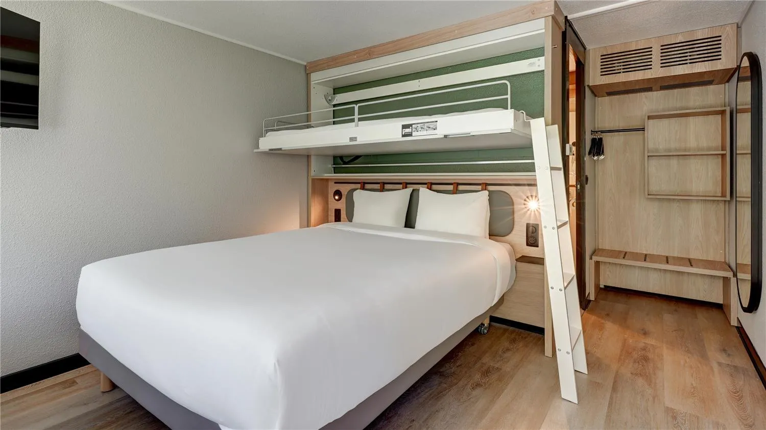 Modern hotel room with white double bed and white bunk bed, light wood furniture, ensuite bathroom and wardrobe at Campanile Nature Bordeaux Lac