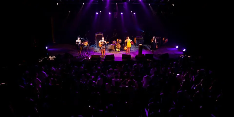 Live concert at Rock School Barbey in Bordeaux with performers on stage under purple stage lighting and audience in the foreground