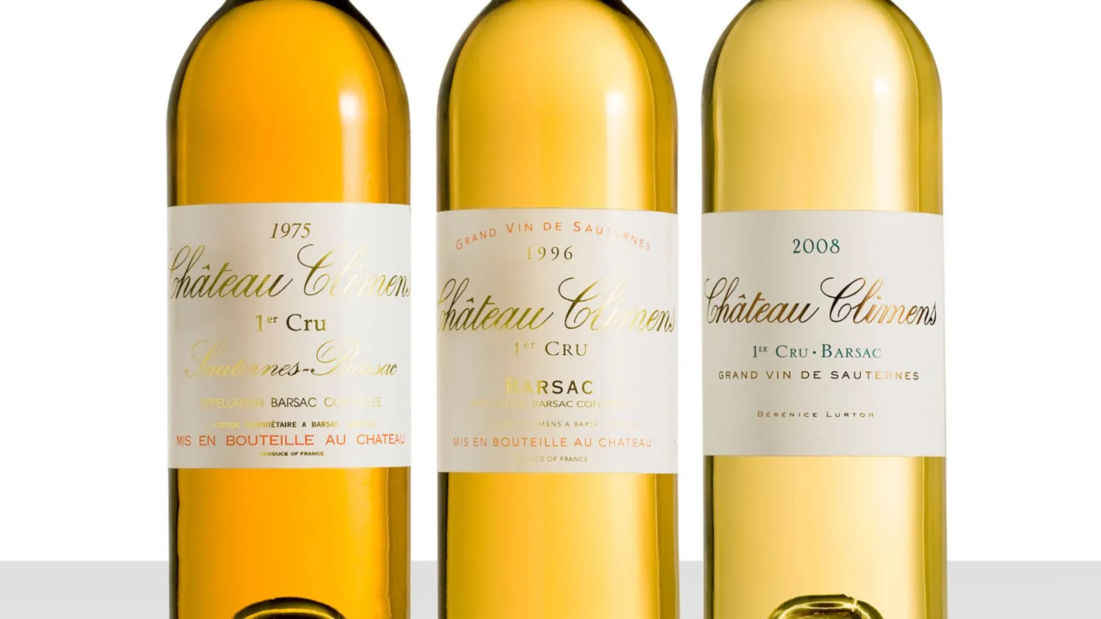 Three bottles of Château Climens, Grand Vin de Sauternes, vintage years 1975, 1996, and 2008, displaying varying shades of golden yellow.