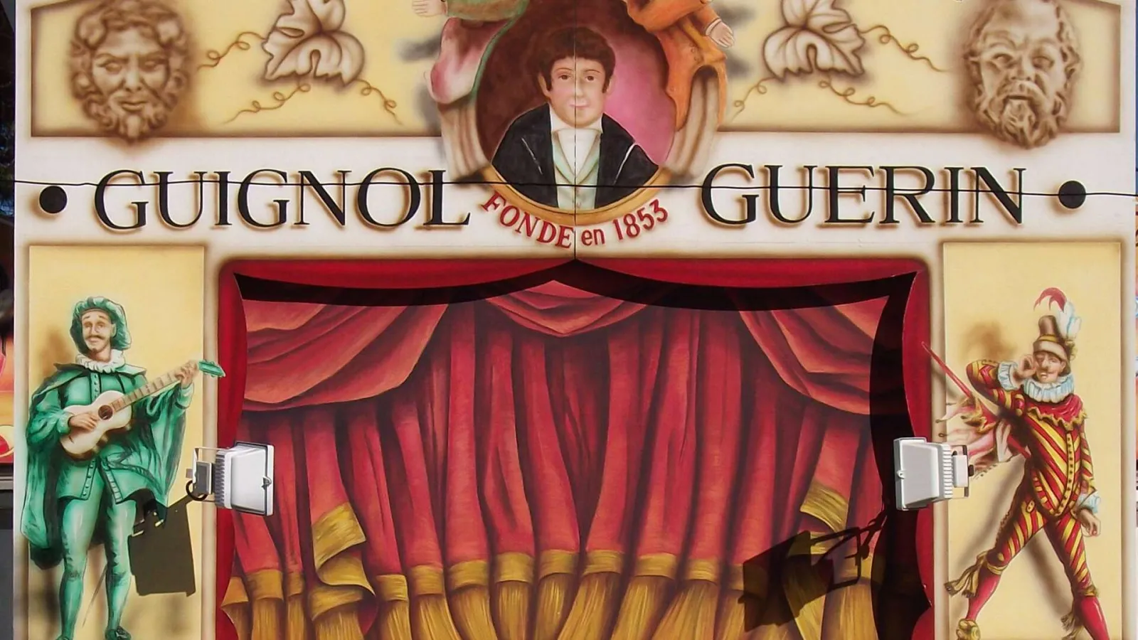 Front of Guignol Guérin Theater in Bordeaux, founded in 1853, featuring red curtain, costumed characters and founder's portrait