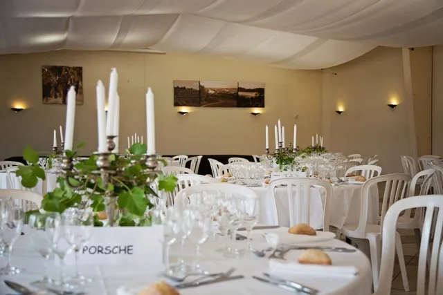 Elegant reception room at the Maison des vins de Cadillac in Bordeaux, featuring white-dressed tables, candelabras, floral arrangements, and refined decoration for an event.