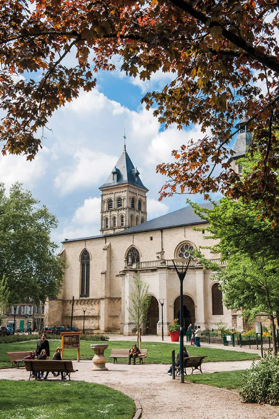 Basilica of Saint-Seurin in Bordeaux with its square bell tower, Romanesque façade, and autumn tree-lined square