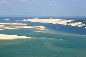 Aerial view of Arcachon Basin showing white sand banks, turquoise waters and characteristic islands