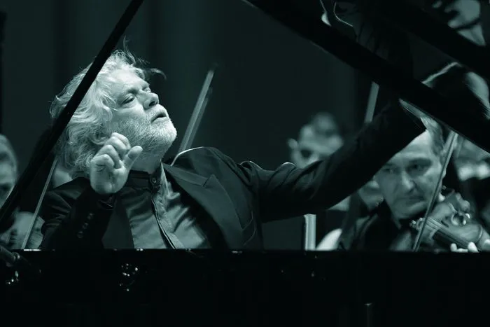 White-haired conductor leading a symphony orchestra during a performance of the Beethoven Saga in Bordeaux