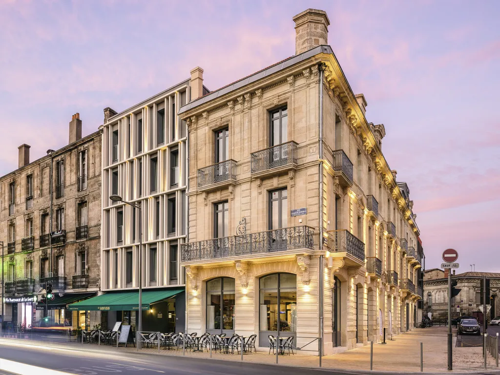 Facade of the Mercure Bordeaux Gare Atlantic Hotel, a Haussmann-style stone building with ground floor terrace, located in Bordeaux.