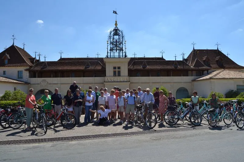 Group of cyclists gathered in front of the Jacobins Convent in Bordeaux, with their bicycles, under clear sky