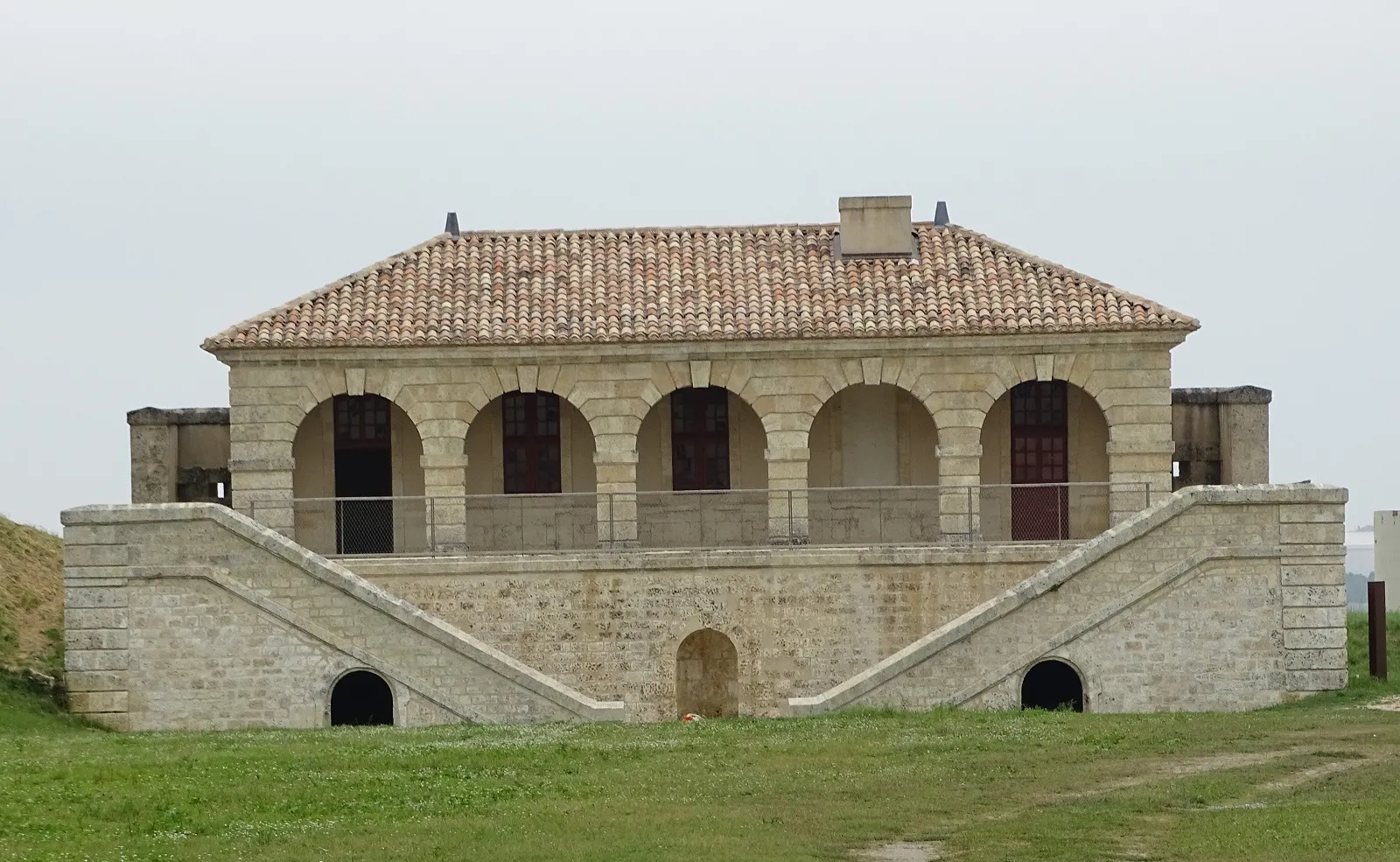 Fort Médoc near Bordeaux, stone fortress featuring five arches on the main facade, tiled roof, and symmetrical access ramps
