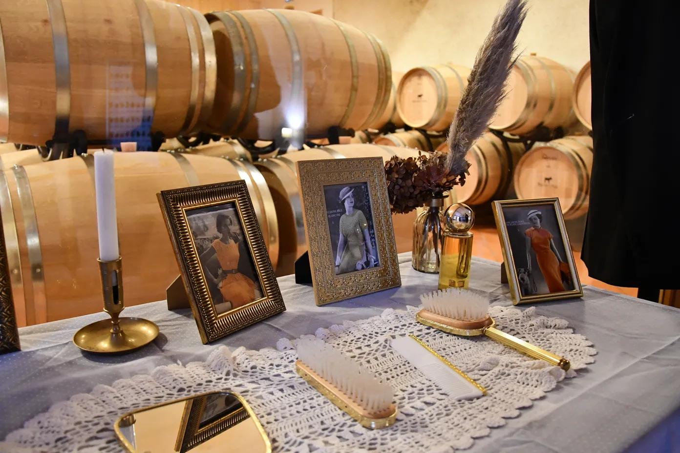 Wine-themed escape game display in Saint-Emilion cellar with wooden barrels, framed portraits, vintage accessories and tasting decorations