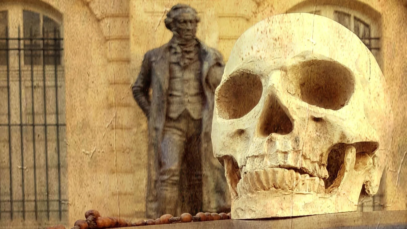 Artistic composition featuring a white skull in the foreground, a bronze statue of an 18th-century dressed man in the background, and prison architecture with bars and stone walls in Bordeaux.