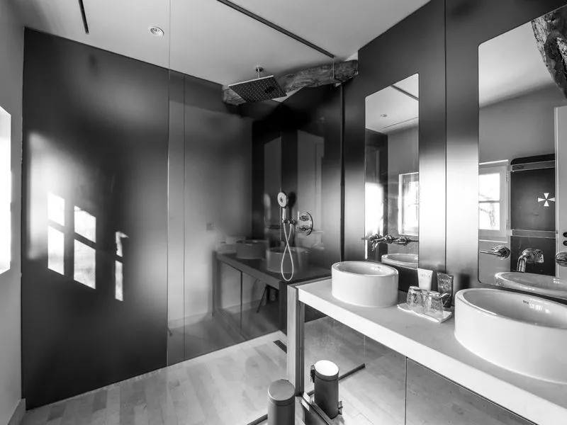 Modern black and white bathroom at Château Beauregard in Bordeaux, featuring walk-in shower, double sink and wall mirror