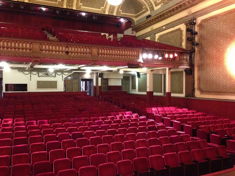 Interior of Bordeaux's Théâtre Fémina with red seats, ornate balcony and classical decor