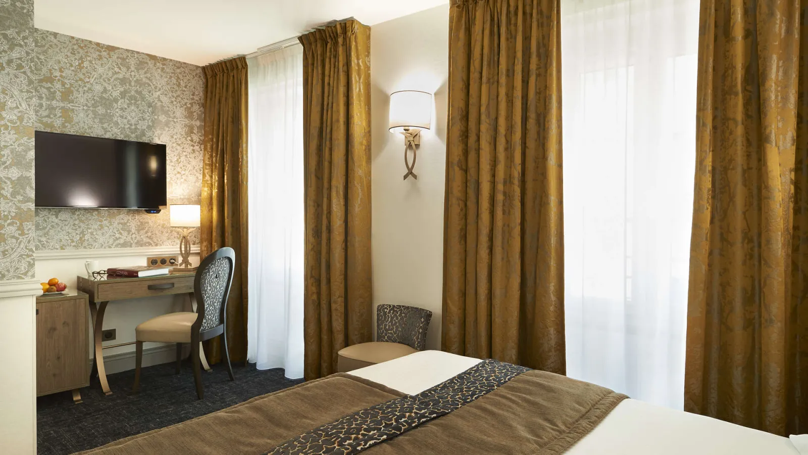 Elegant hotel room featuring a double bed, desk with flat-screen TV, gold curtains and ornamental beige wallpaper at Best Western Premier Hôtel Bayonne Etche Ona in Bordeaux