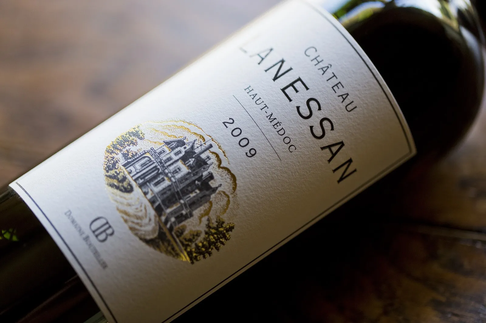 Bottle of Château Lanessan 2009 red wine, Haut-Médoc, featuring a white label with gold-embossed château illustration.