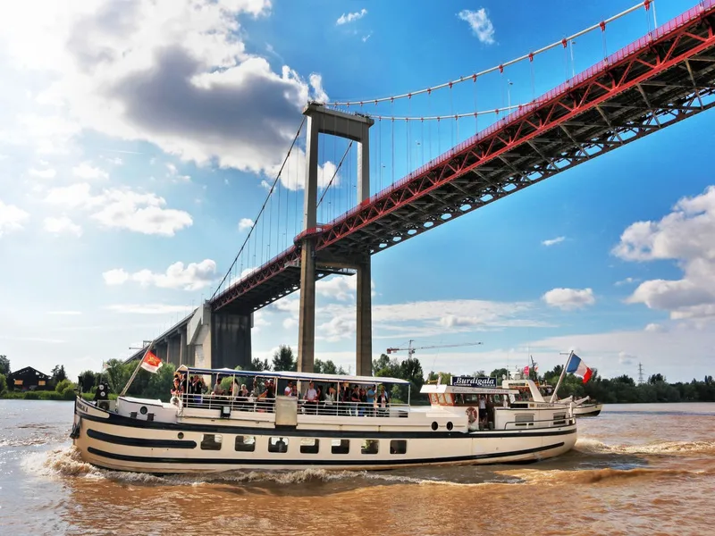 Burdigala cruise ship sailing under the Stone Bridge in Bordeaux on a sunny day
