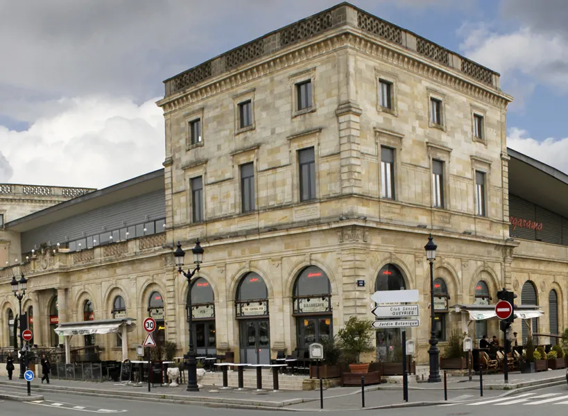 Mégarama Bordeaux Bastide cinema, a historic stone building with arched ground floor openings and regular upper floors, located in Bordeaux