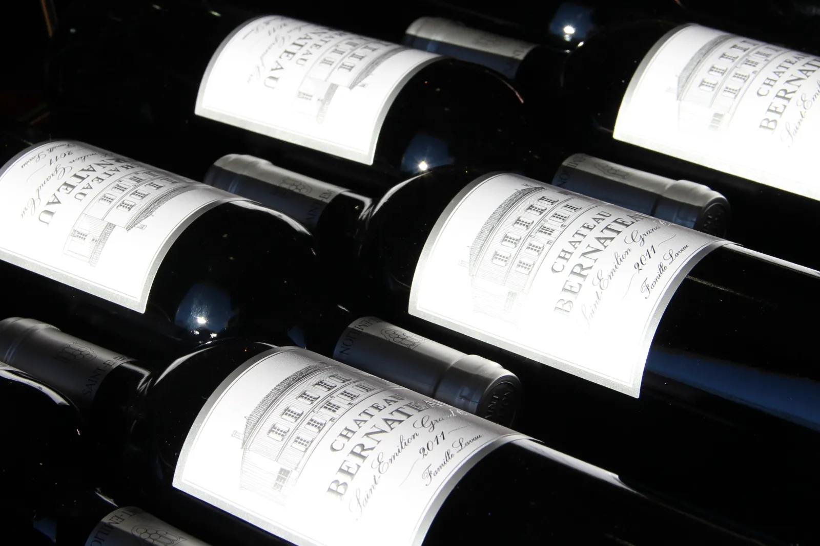 Collection of Château Bernateau Bordeaux wine bottles arranged in a rack with white labels visible