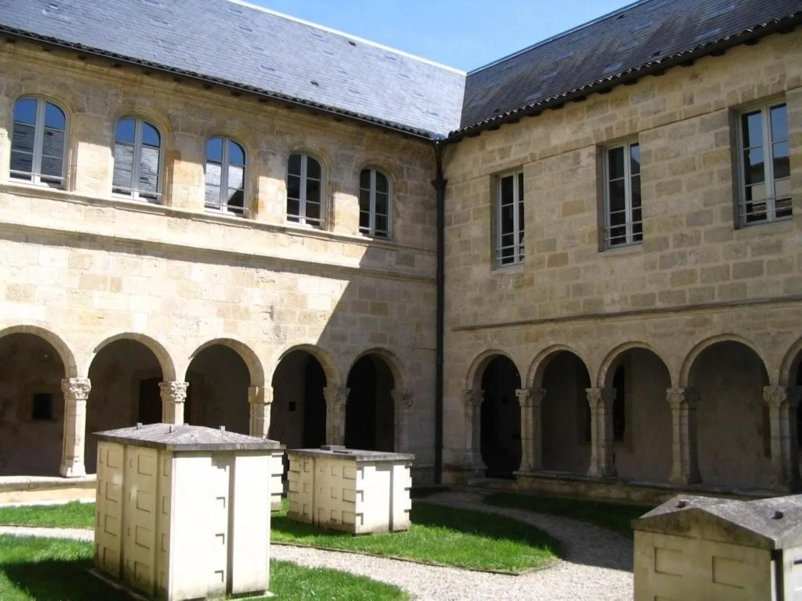 Interior courtyard of the Convent of the Annunciation in Bordeaux featuring stone arcaded galleries, central lawn and dressed stone buildings
