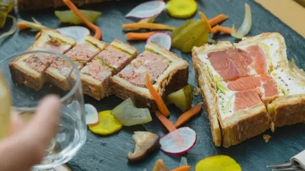 Slate plate with sliced foie gras and country ham terrine garnished with vegetables and gherkins, from La Manufacture Le Bayon in Bordeaux
