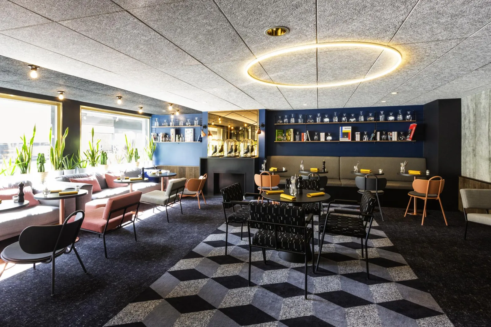 Modern reception area in Bordeaux featuring contemporary furniture, decorative shelving, innovative lighting, and city views