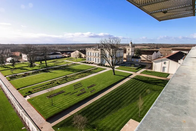 Aerial view of Château Gruaud Larose in Bordeaux featuring manicured French gardens, striped lawns and historic buildings