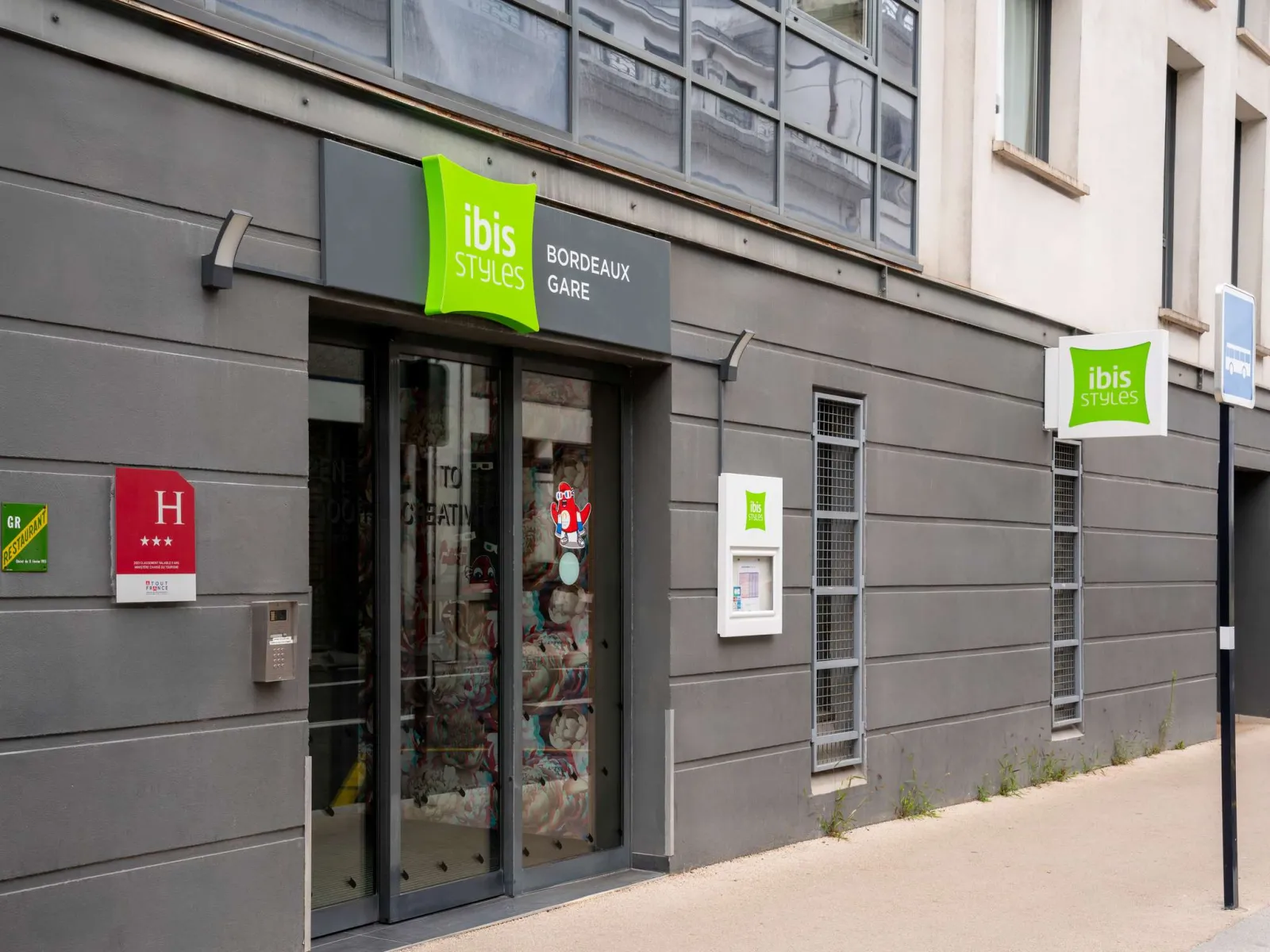 Storefront of the Ibis Styles Bordeaux Gare hotel featuring the brand's iconic green signage, located near Bordeaux train station