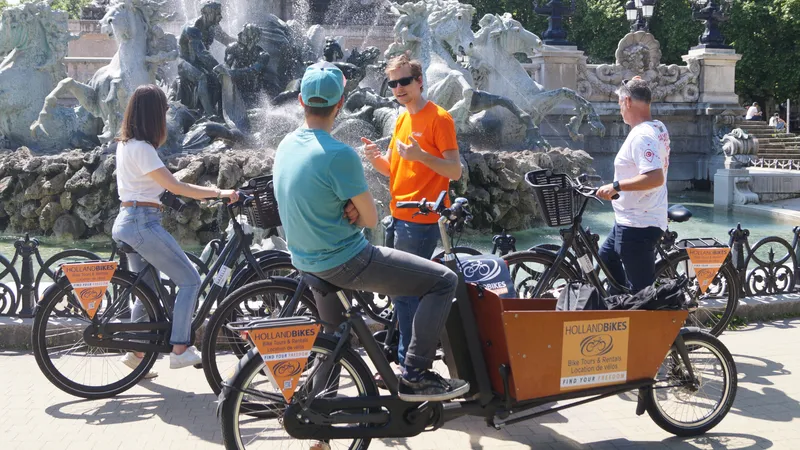 Group of tourists on Holland Bikes bicycles in front of the fountain at Place de la Bourse in Bordeaux during a guided bike tour