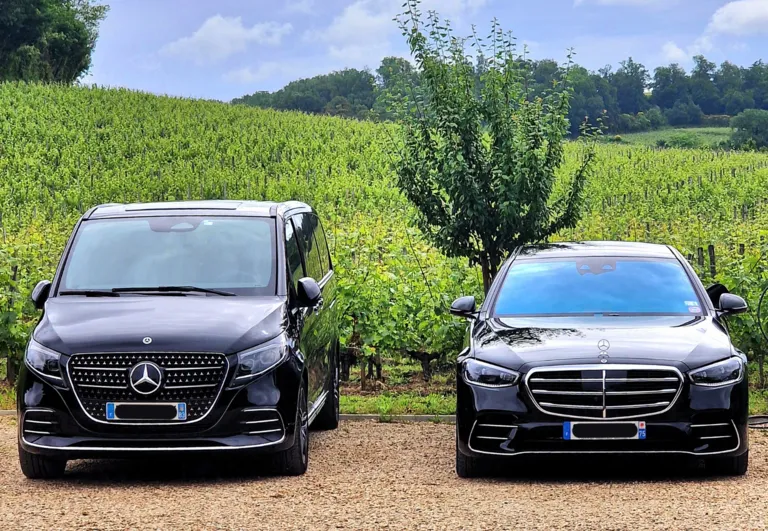 Two luxury Mercedes-Benz vehicles parked side by side on a dirt road, with lush vineyards in the background near Bordeaux.
