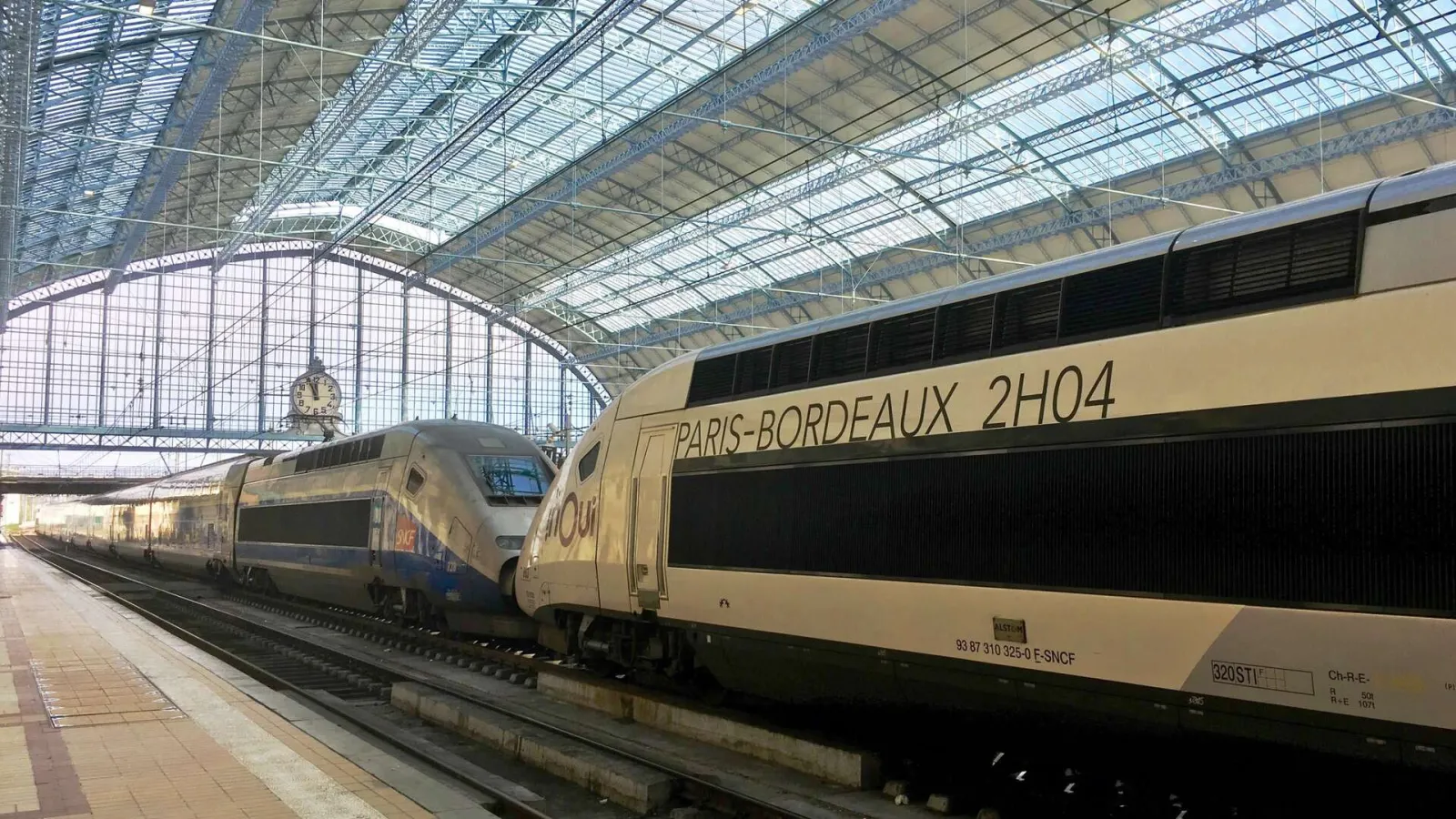 A TER Paris-Bordeaux train parked at Bordeaux Saint-Jean railway station under the metal and glass canopy of the main building