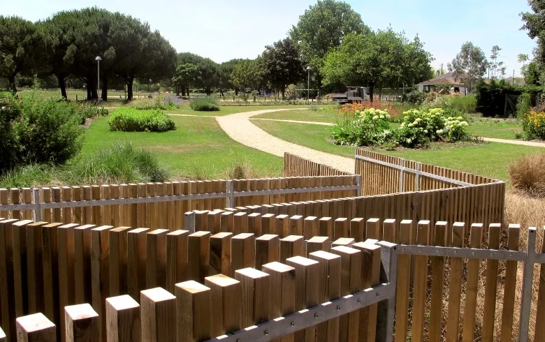Bordeaux's Bords de Jalle de Gajac park featuring wooden fence, winding path, green spaces and trees