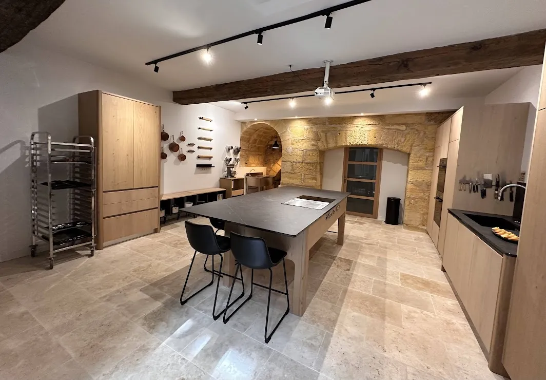 Modern spacious cooking kitchen at The Gastronome Bordeaux cooking school, featuring a central island, premium appliances, and light wood furnishings.