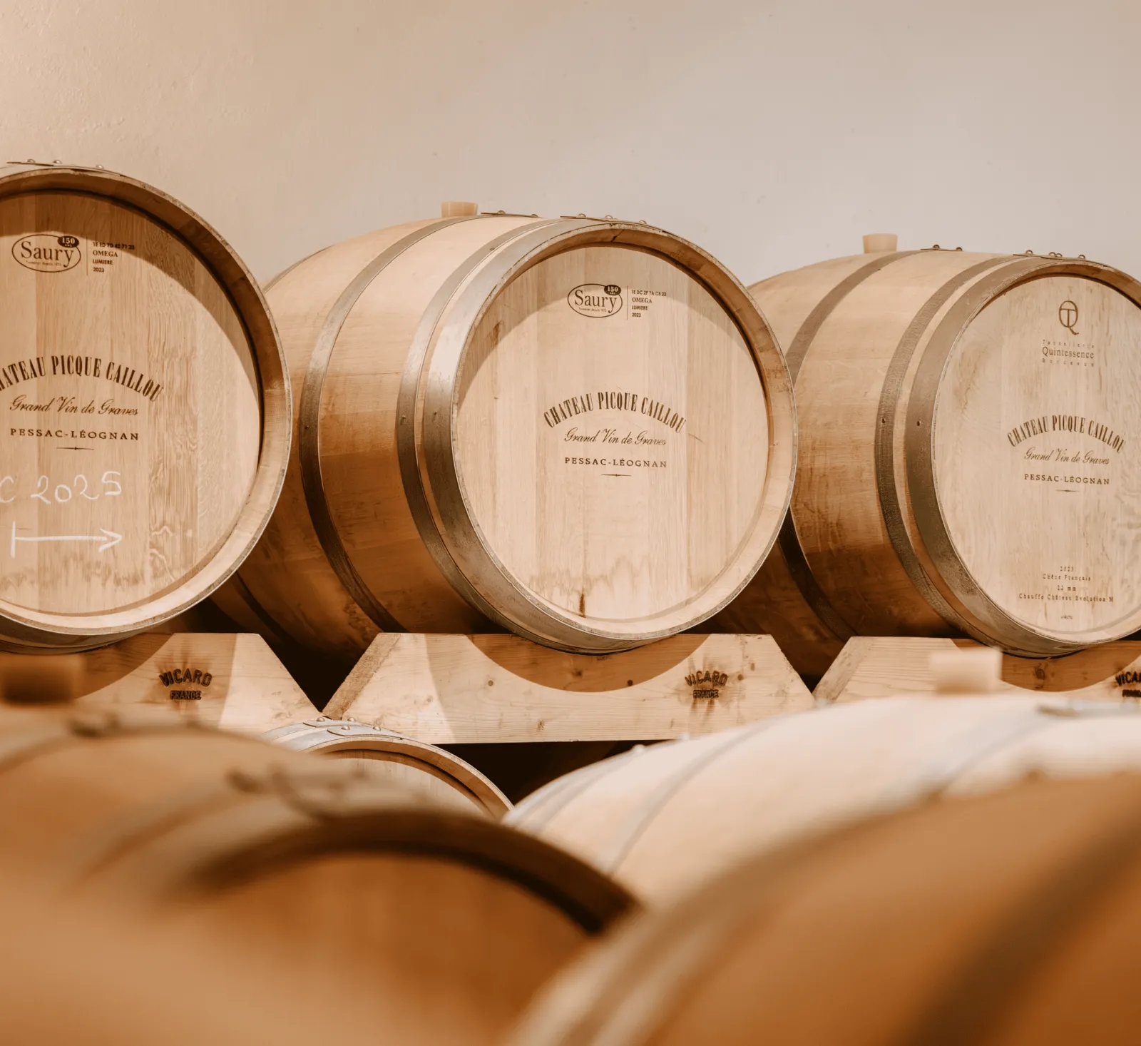 Oak barrels lined up in the cellar of Château Picque Caillou in Bordeaux, used for wine aging