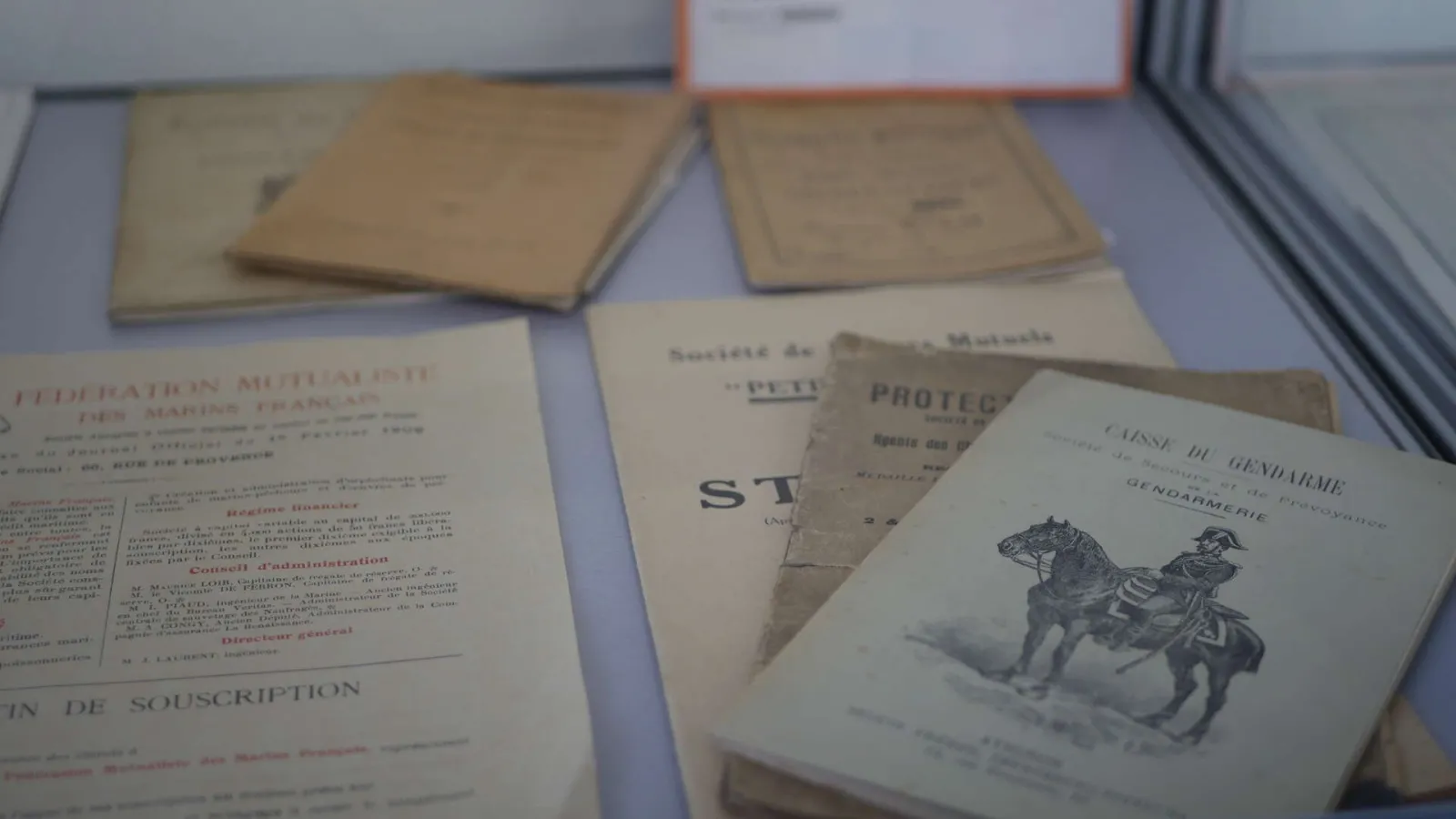 Historical French documents from the early 20th century about health insurance and gendarmerie, displayed at the National Museum of Health Insurance in Bordeaux.