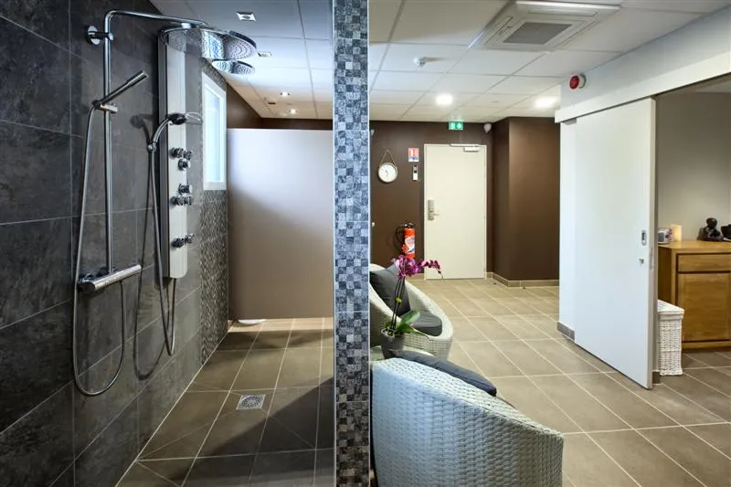 Modern wellness area of Au Comté d'Ornon hotel in Bordeaux, featuring a walk-in shower with massage jets and access to the relaxation and reception area