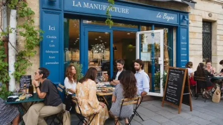 Blue storefront of La Manufacture Le Bayon in Bordeaux with customers seated at outdoor tables in front of the café-restaurant