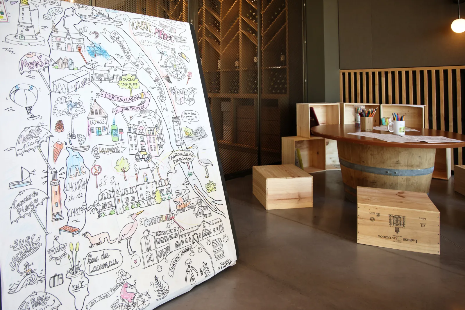 Illustrated map of Bordeaux displayed in a reception room with wooden counter, featuring the city's landmarks and tourist attractions including Château Larose-Trintaudon.