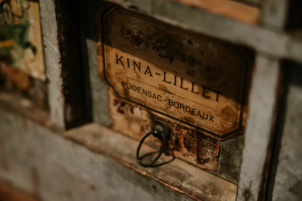 Vintage Kina-Lillet sign from Bordeaux displaying the producer name and Podensac-Bordeaux designation on a weathered wall
