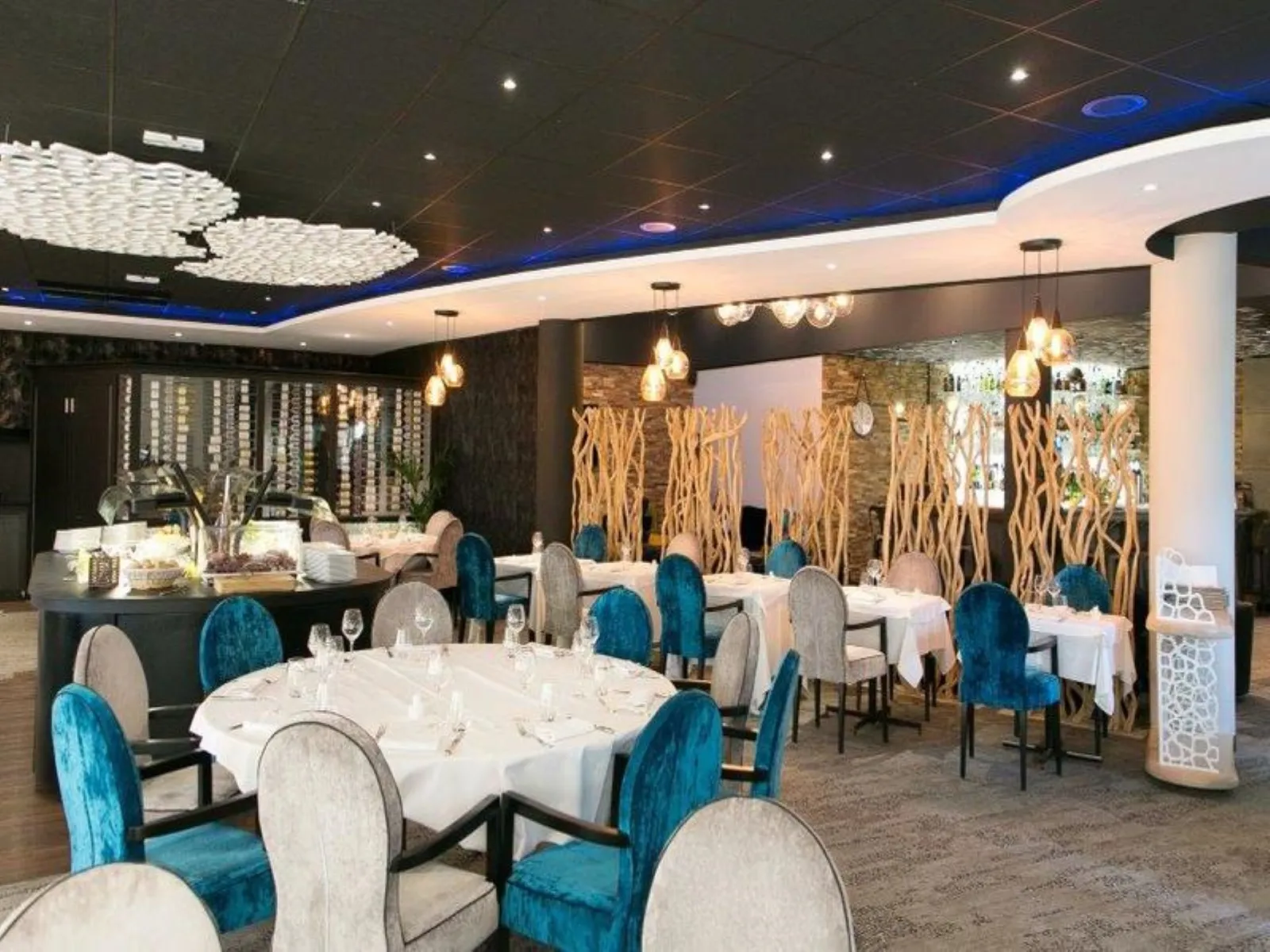 Elegant restaurant interior with round dining tables, blue and grey chairs, natural wood decoration, dark blue ceiling and modern lighting fixtures