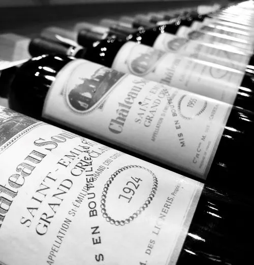 Row of Bordeaux wine bottles from Château Soutard lined up, black and white photograph displaying labels with 1974 vintage.