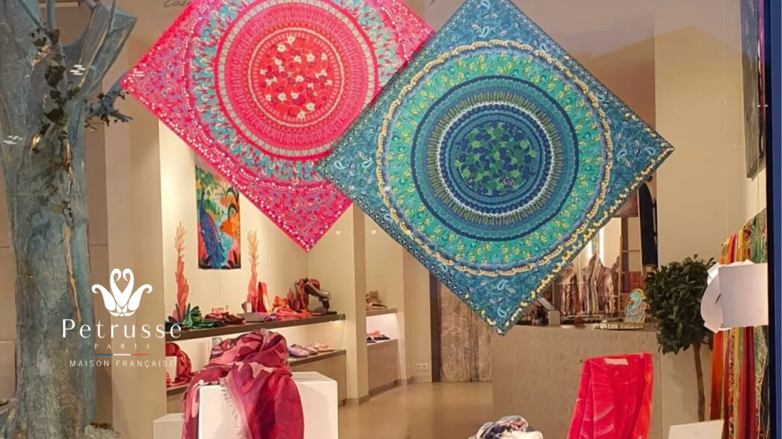Petrusse boutique in Bordeaux displaying colorful textiles with geometric circular patterns in pink and blue, featured on wall panels and display stands.