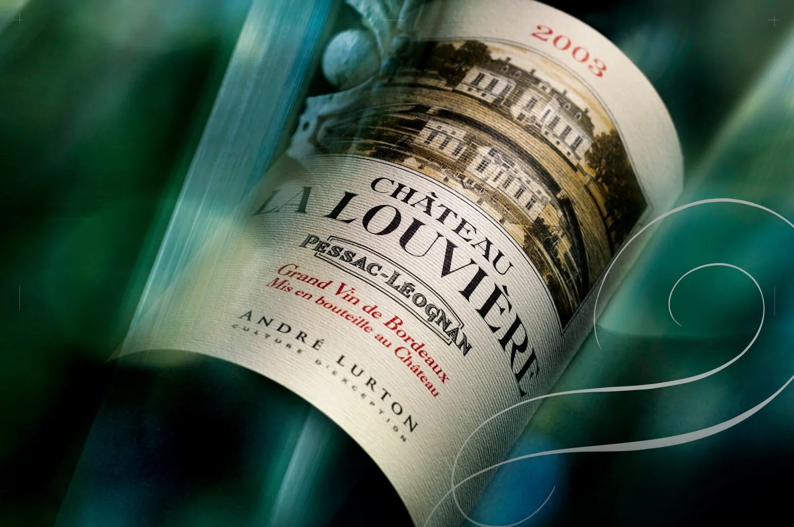 Bottle of Château La Louvière 2003 red wine, a Grand Cru from Pessac-Léognan Bordeaux, produced by André Lurton, photographed against a turquoise background.