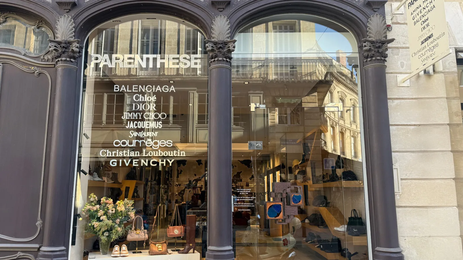 Storefront of Parenthese luxury boutique in Bordeaux featuring designer brands including Balenciaga, Chloé, Dior, Jimmy Choo, Jacquemus, Saint Laurent, Courreges, Christian Louboutin and Givenchy, with accessories and clothing on display.