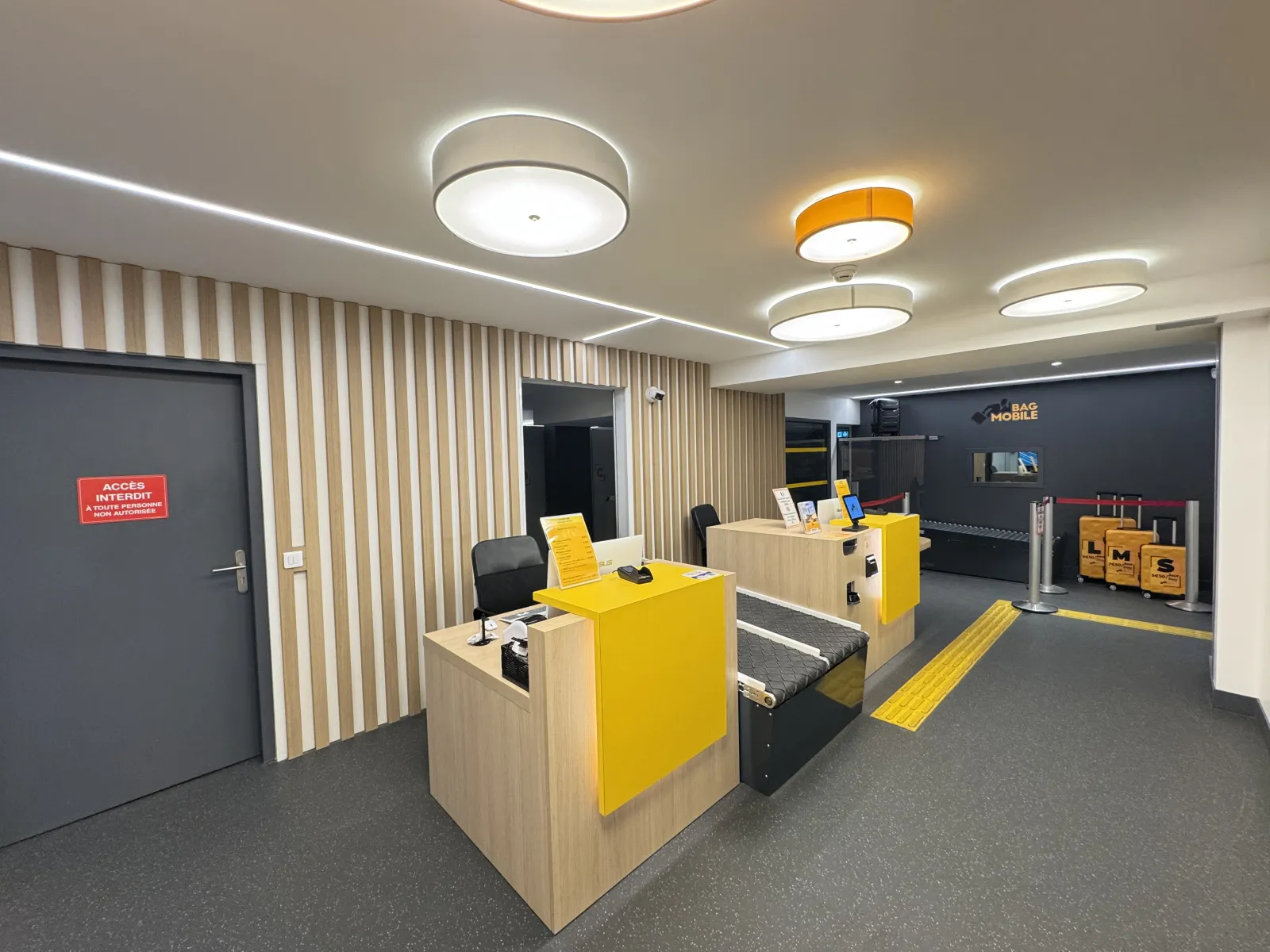 Modern interior of a Bag Mobile store in Bordeaux featuring yellow and black counters, contemporary furniture, LED lighting, and French signage.
