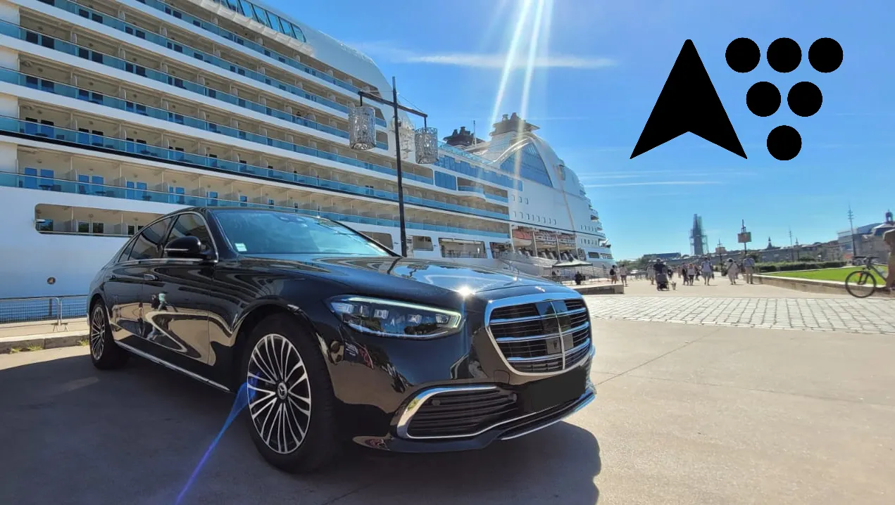 Black luxury car parked on Bordeaux waterfront with a large cruise ship in the background and city skyline