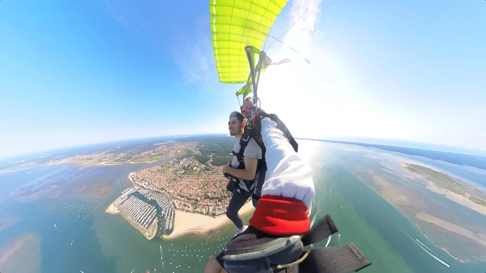 Skydiver in freefall above Bordeaux city with aerial view of urban development, tidal basins and Gironde estuary
