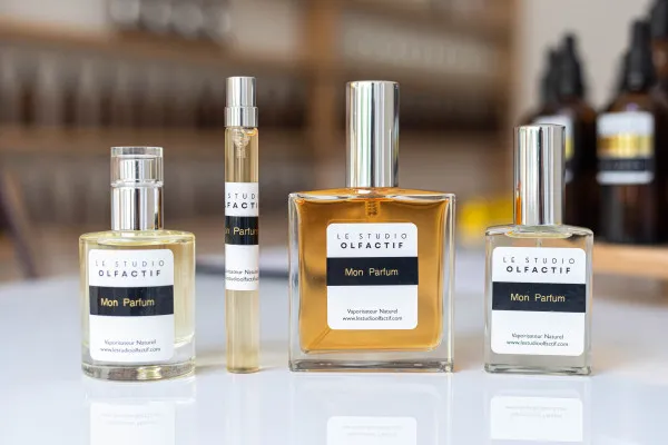 Mon Parfum fragrance bottles collection from Bordeaux's Studio Olfactif, displaying multiple glass perfume bottles in different sizes with black labels and silver caps.