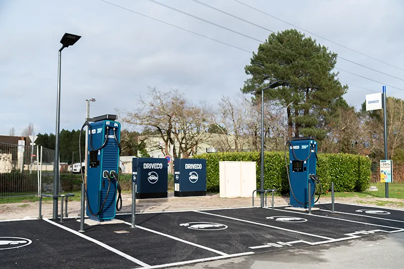 Driveco electric vehicle charging station with two blue charging points, waste bins, and street lighting, located near Kyriad Direct Bordeaux Sud Cestas hotel.